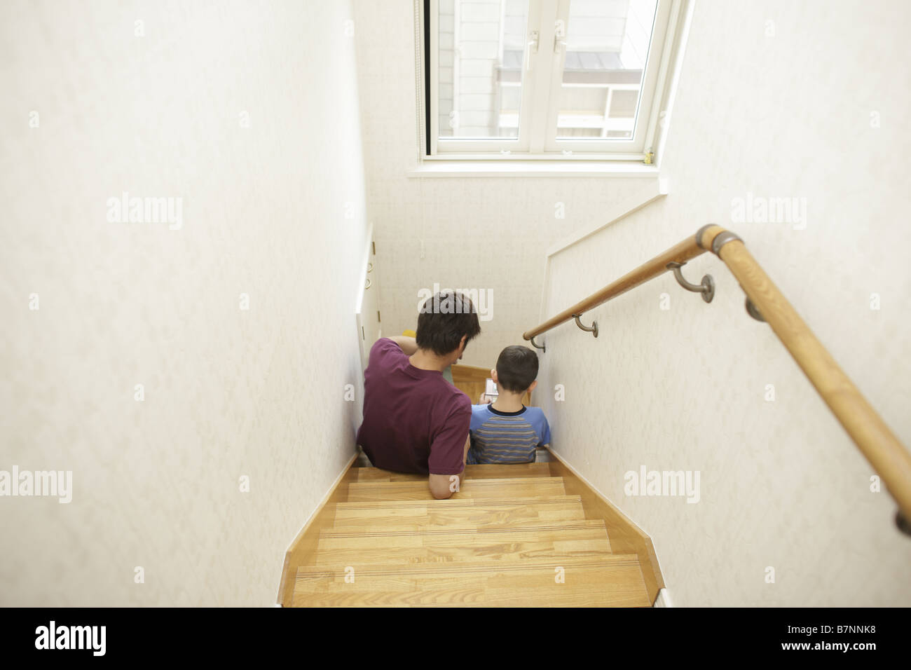 Father and son  playing with handheld video game Stock Photo