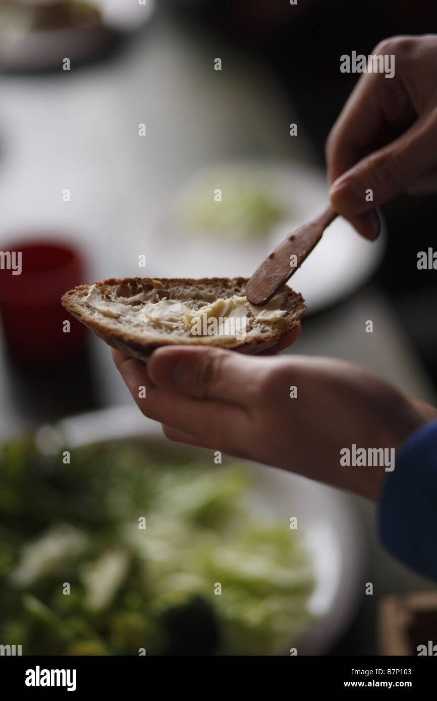 Spreading bread with butter Stock Photo Alamy