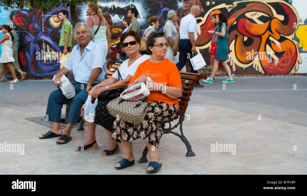 Heraklion / Irakleo, Crete, Greece. Men and women sitting on bench in Plateia Veneziou Stock Photo