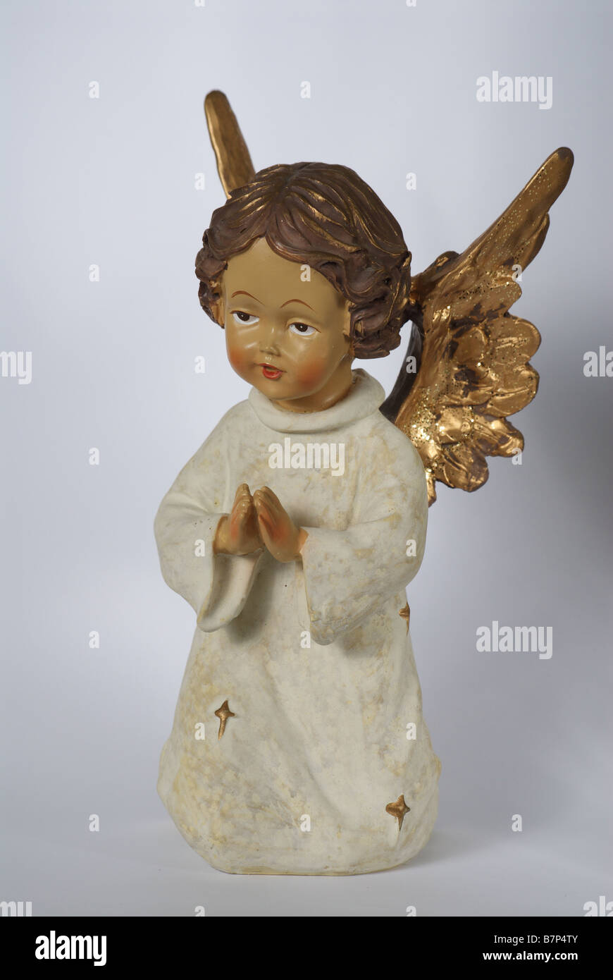 Angel with golden wings and hands put together Stock Photo