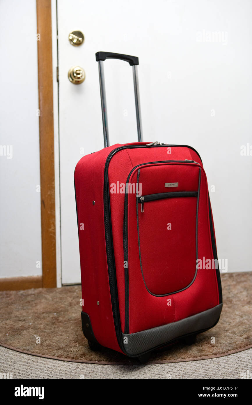 A suitcase next to the door Stock Photo