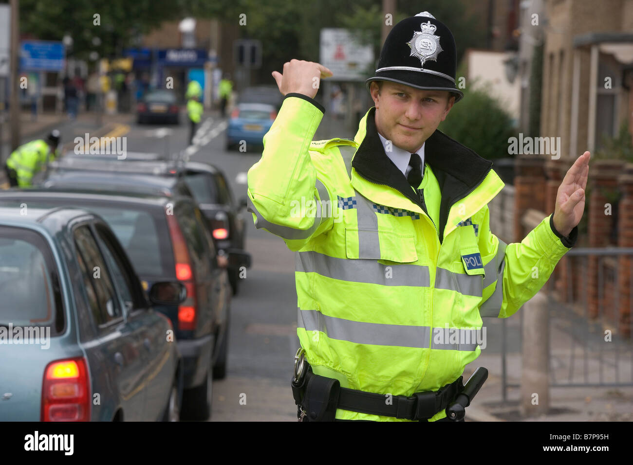 A Special Constable waves on traffic as supporters arrive for the Watford Burnley match at Watford Stadium Stock Photo