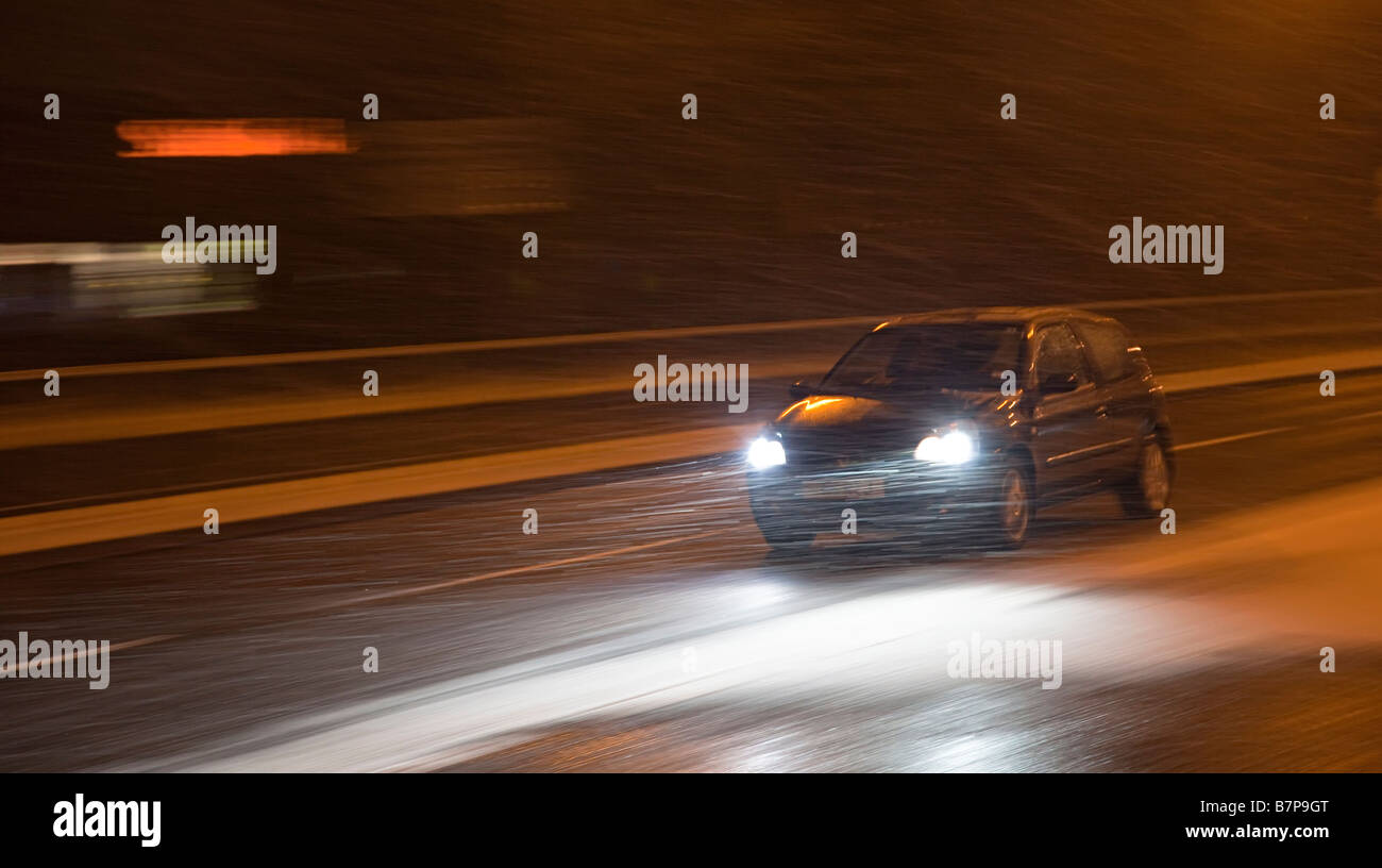 Car Driving Down Road At Night