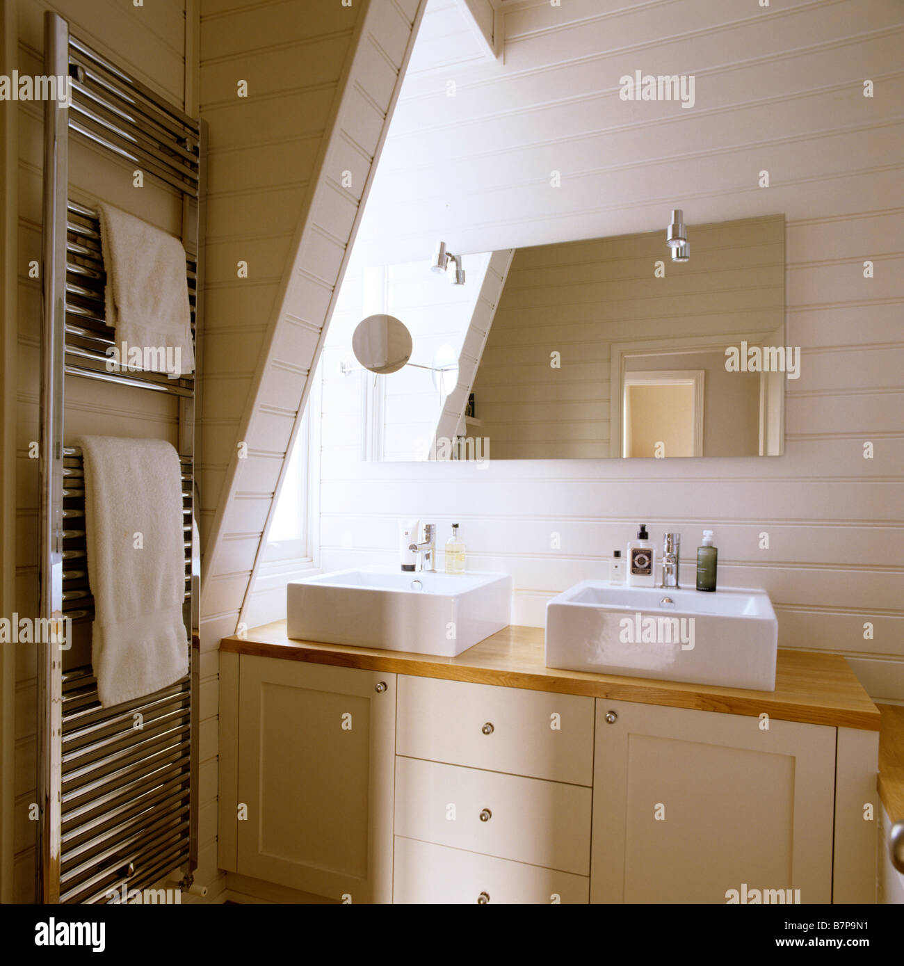 Modern wood panelled bathroom with double basin and metallic towel rail