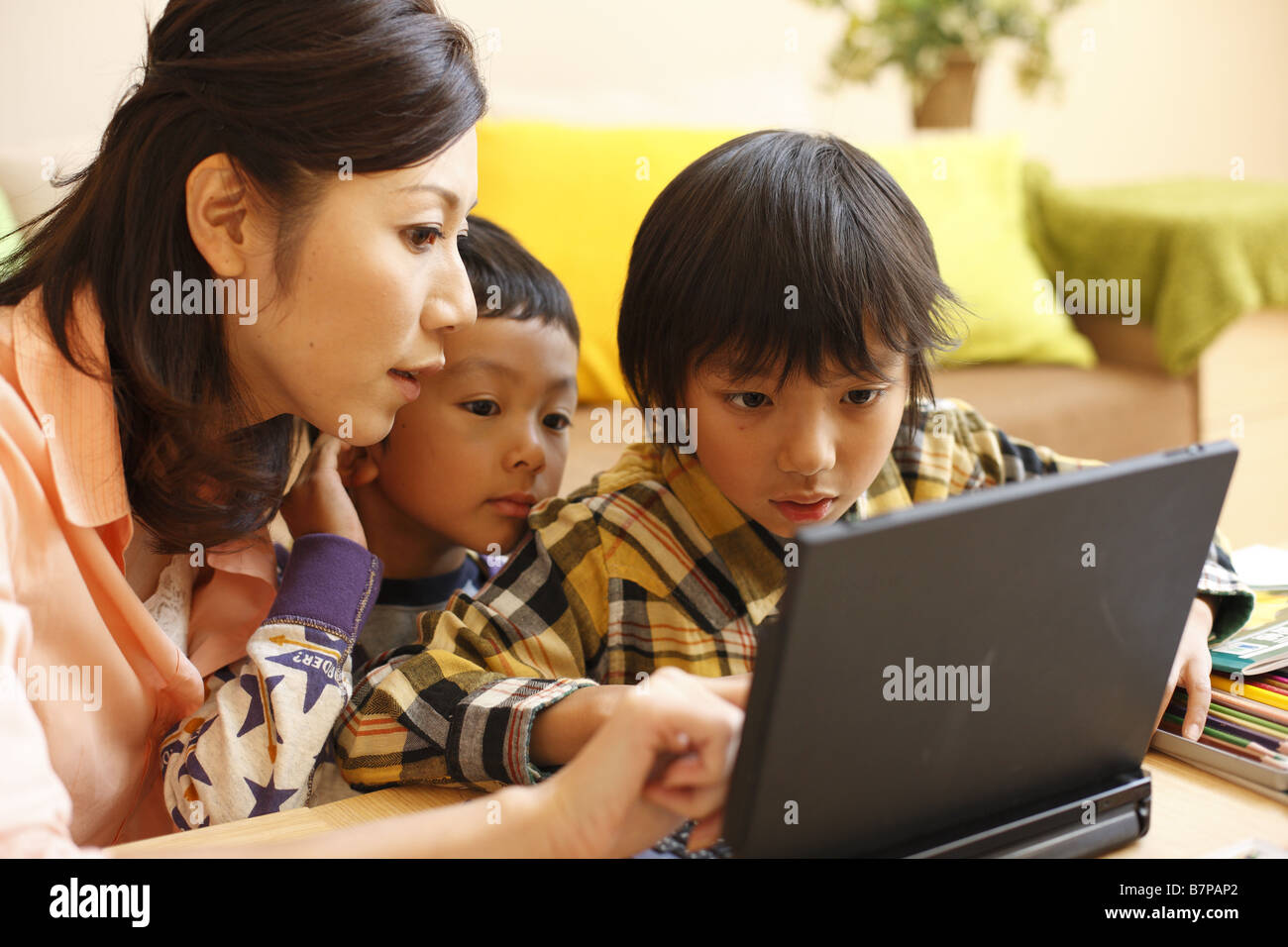 Mother and children using laptop Stock Photo - Alamy