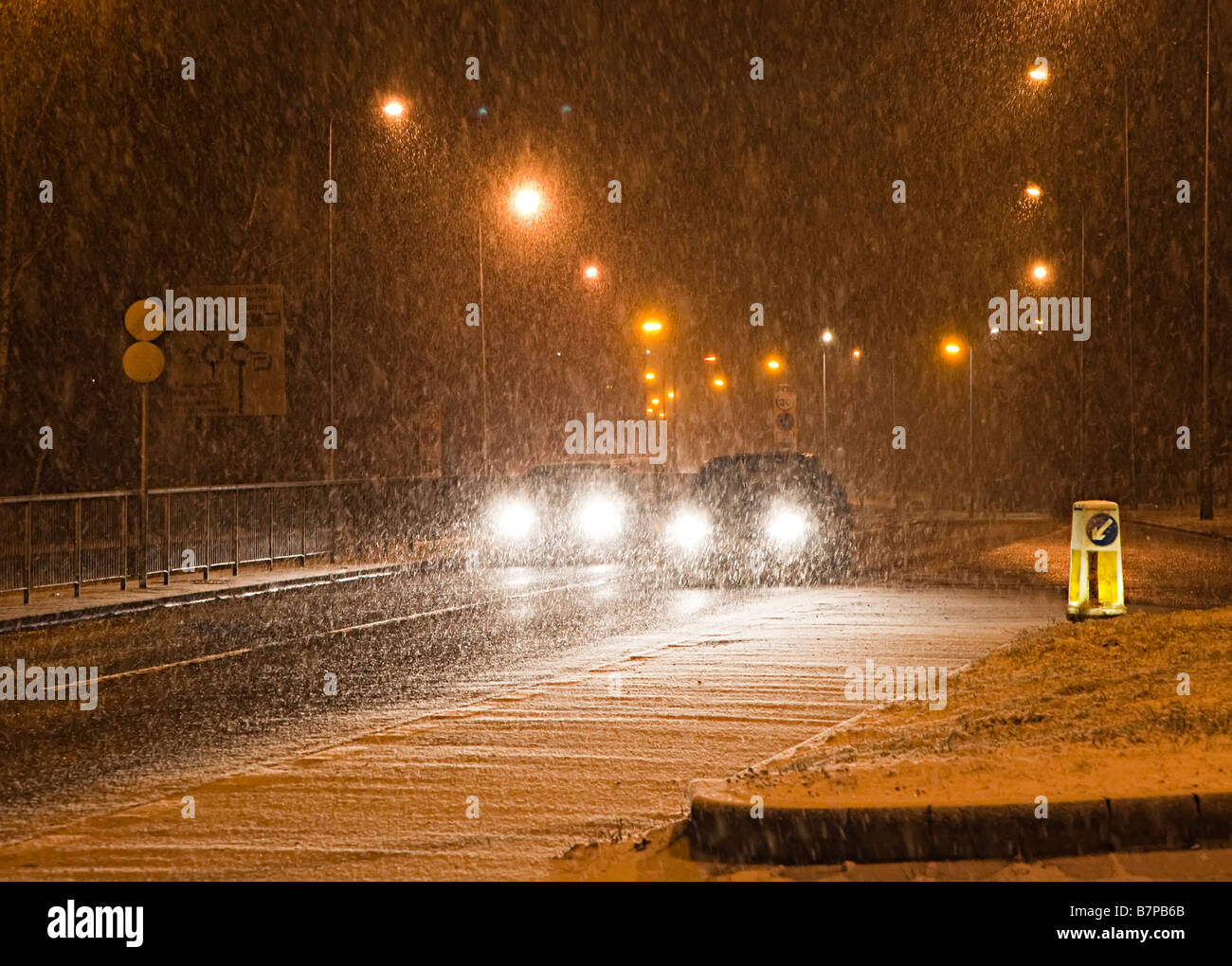 Cars driving at night in winter snowing conditions Cwmbran Wales UK Stock Photo