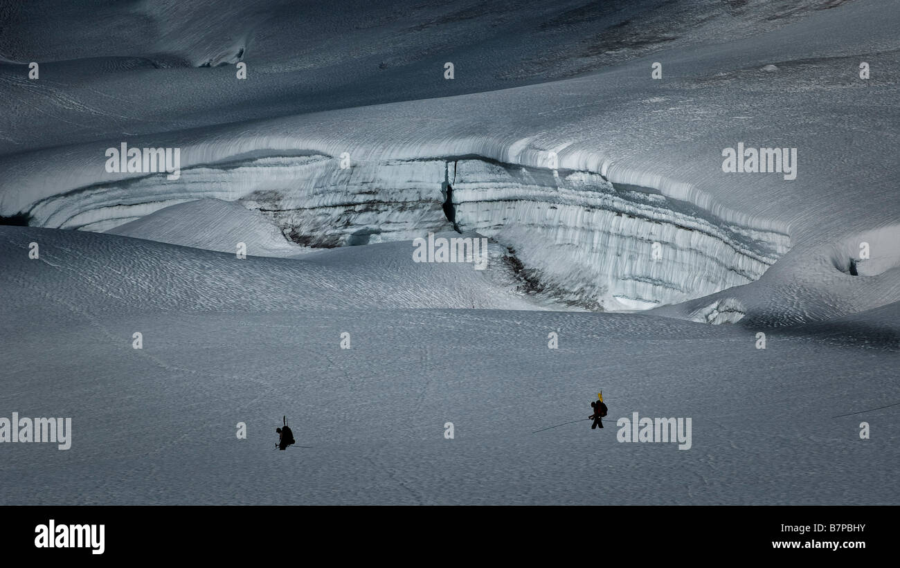 Two climbers roped together below a snow crevasse. Stock Photo