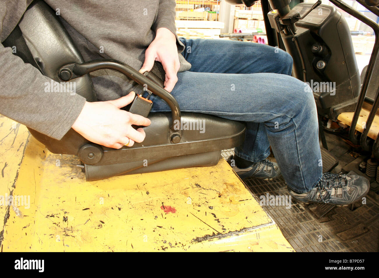 forklift truck driver putting on seat-belt Stock Photo - Alamy