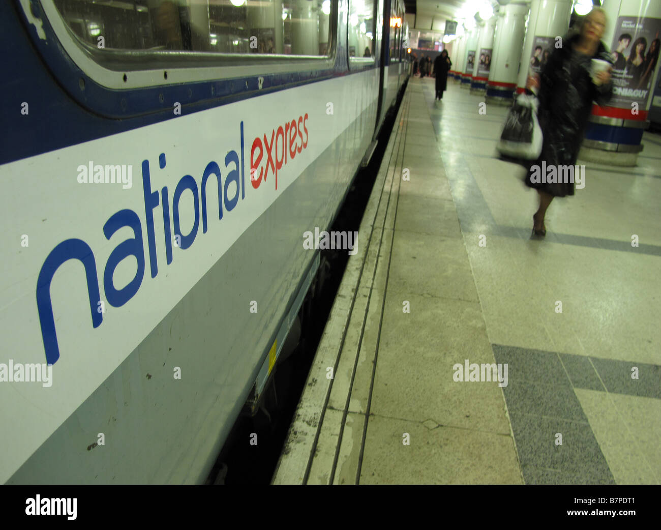 A woman walks past a National Express East Anglia train at Liverpool Street Station Stock Photo