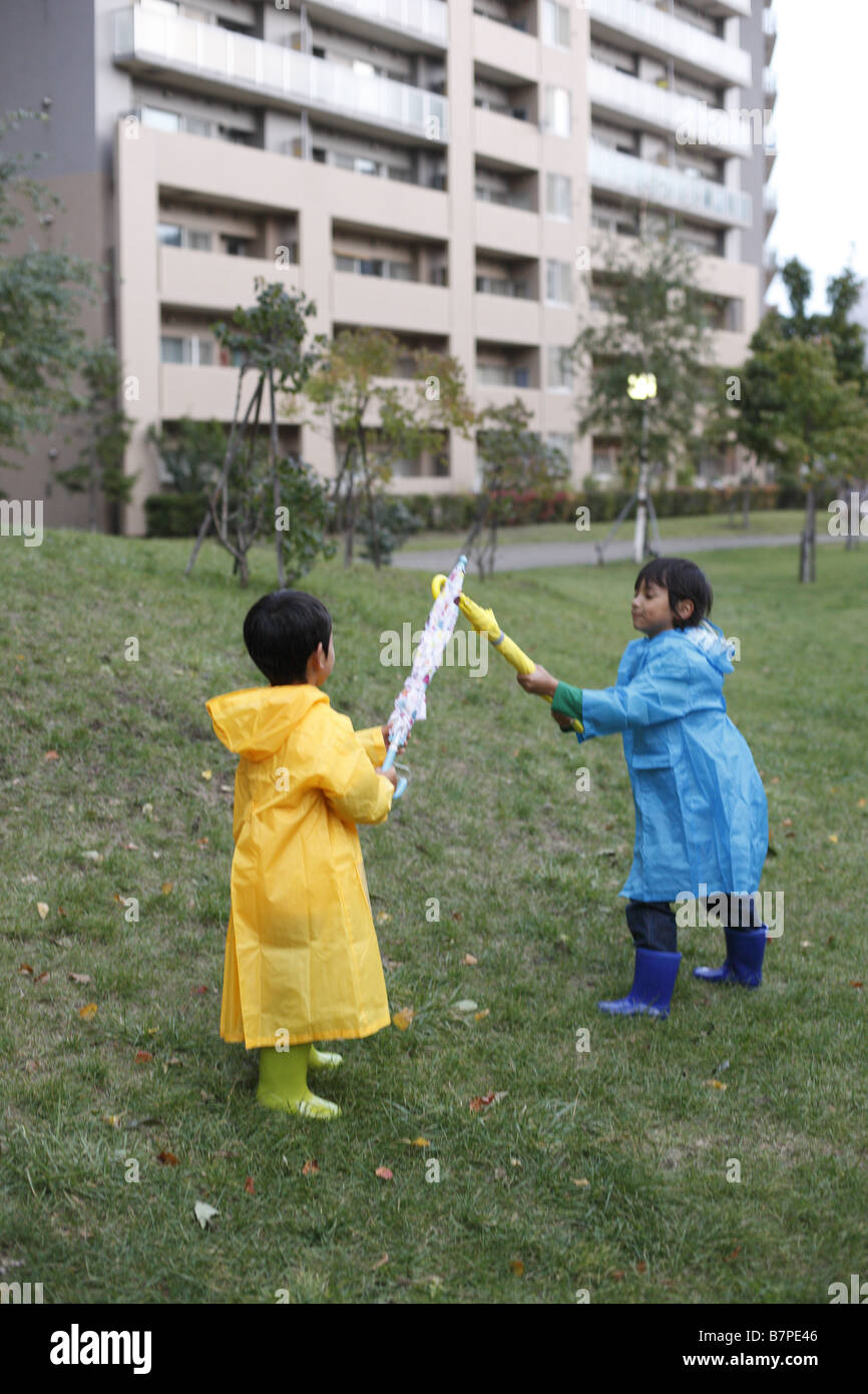 Brothers playing with umbrellas Stock Photo