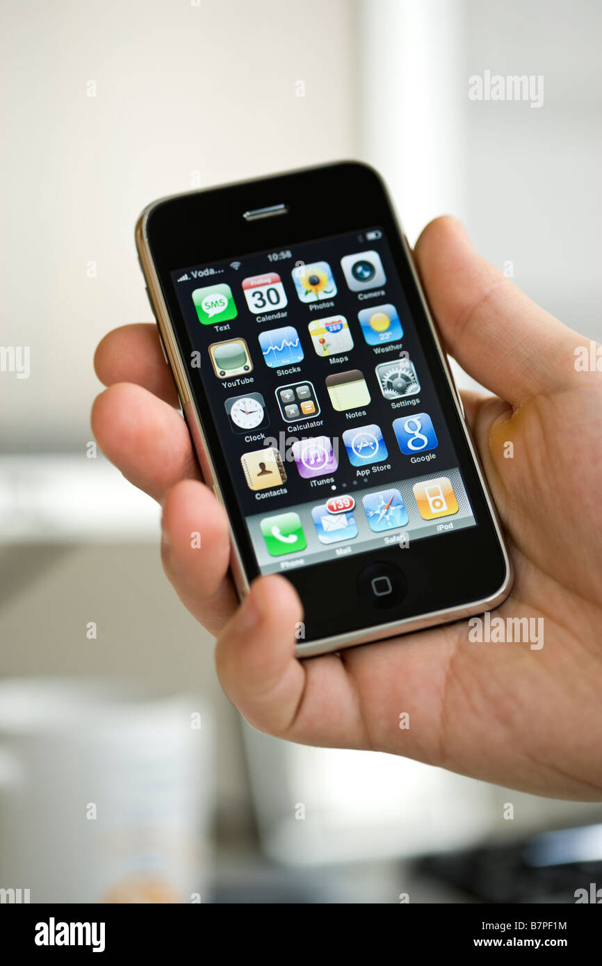 hand holding iPhone 3G, main menu on screen Stock Photo