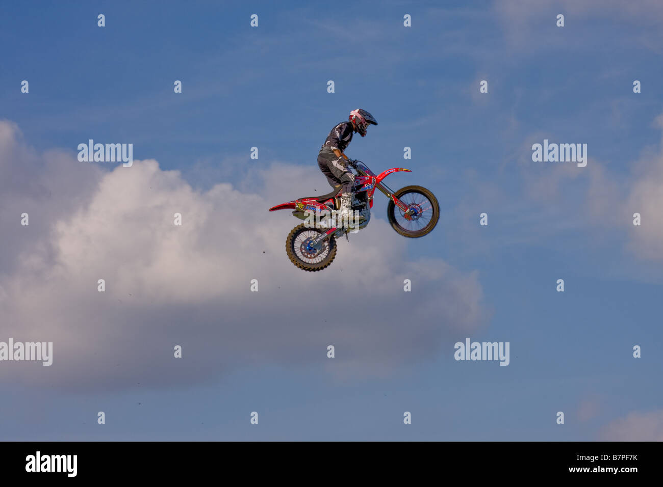 A daredevil stunt motorbike rider jumping through the air Stock Photo