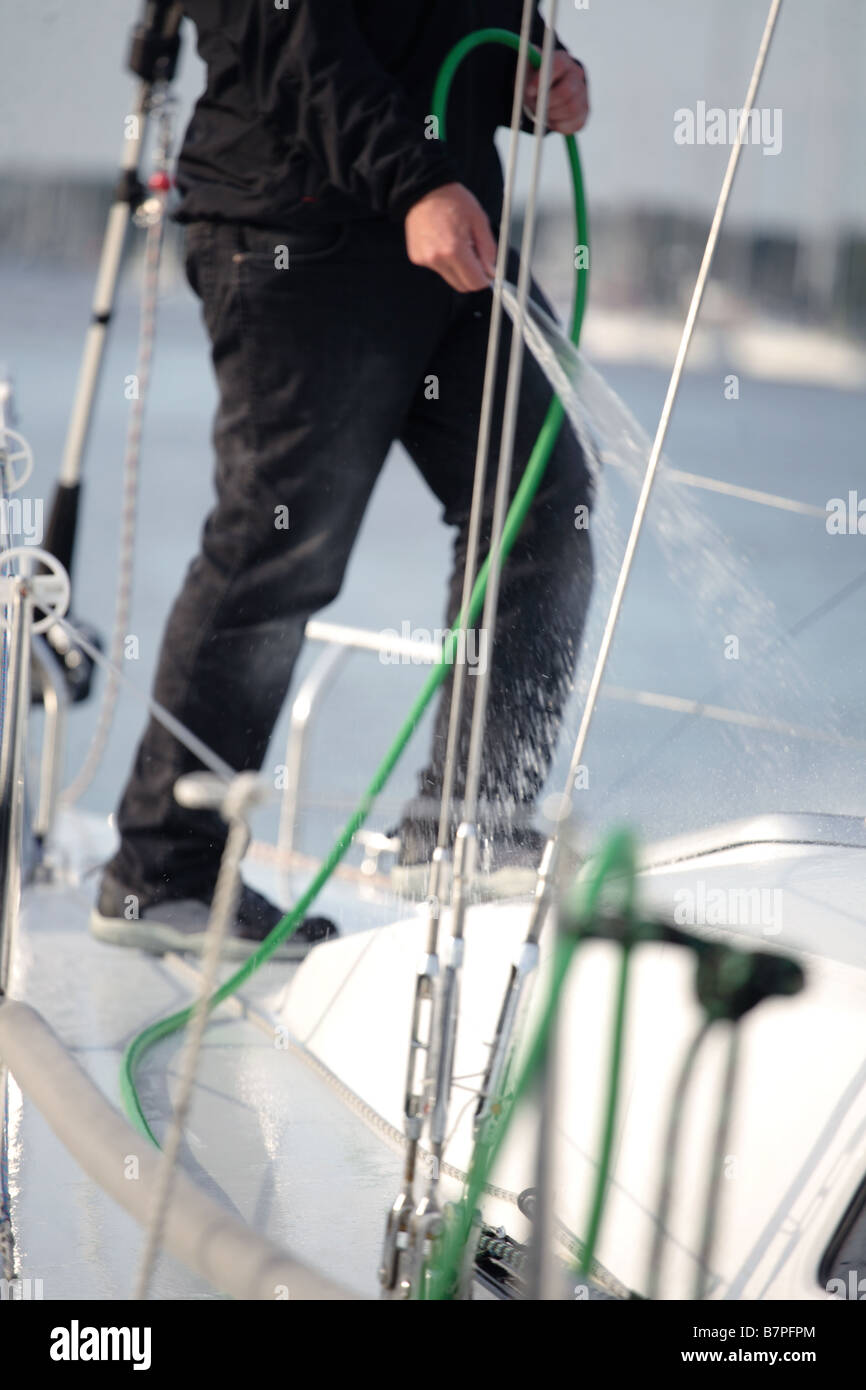 sailor washing his boat down after a sailing trip. Stock Photo