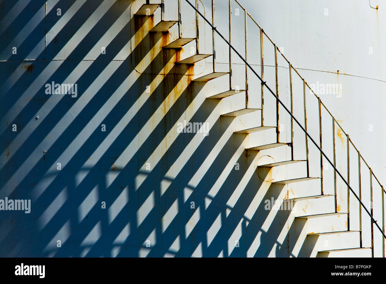 Spiral staircase leading upward, metal abandoned fuel tank. Stock Photo