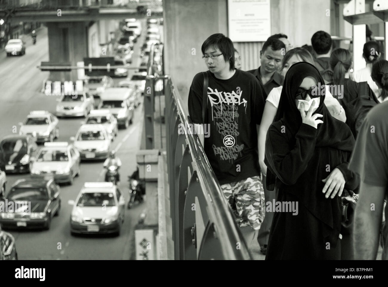 Woman trying to avoid traffic pollution with handkerchief Pathumwan district in central Bangkok Thailand Stock Photo