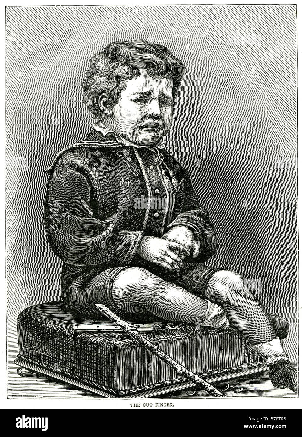 the cut finger sad upset boy injured child inside sitting tears house holding hand traditional clothing Stock Photo