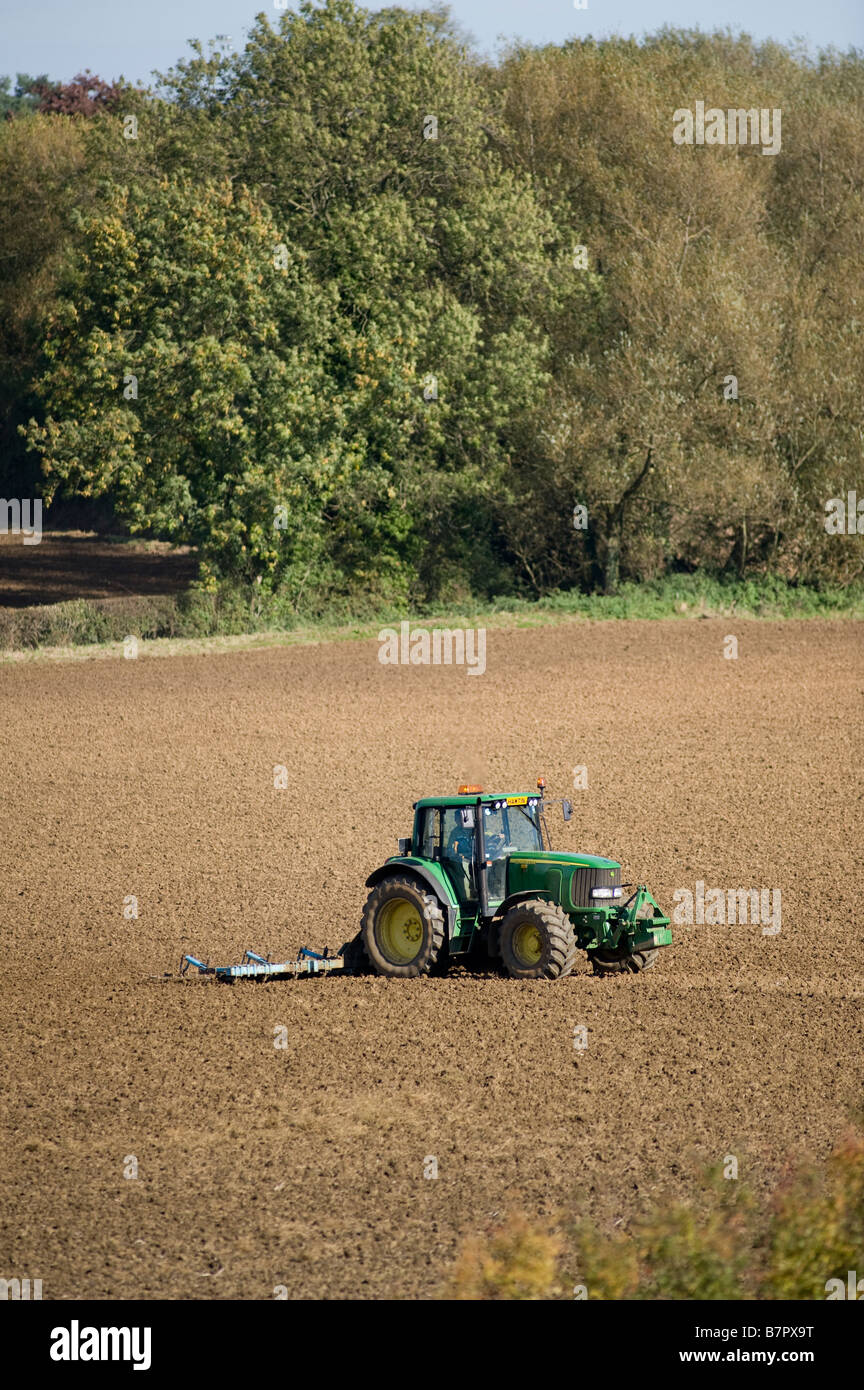 Farmer with a green John Deere tractor in a field on his farm in the ...