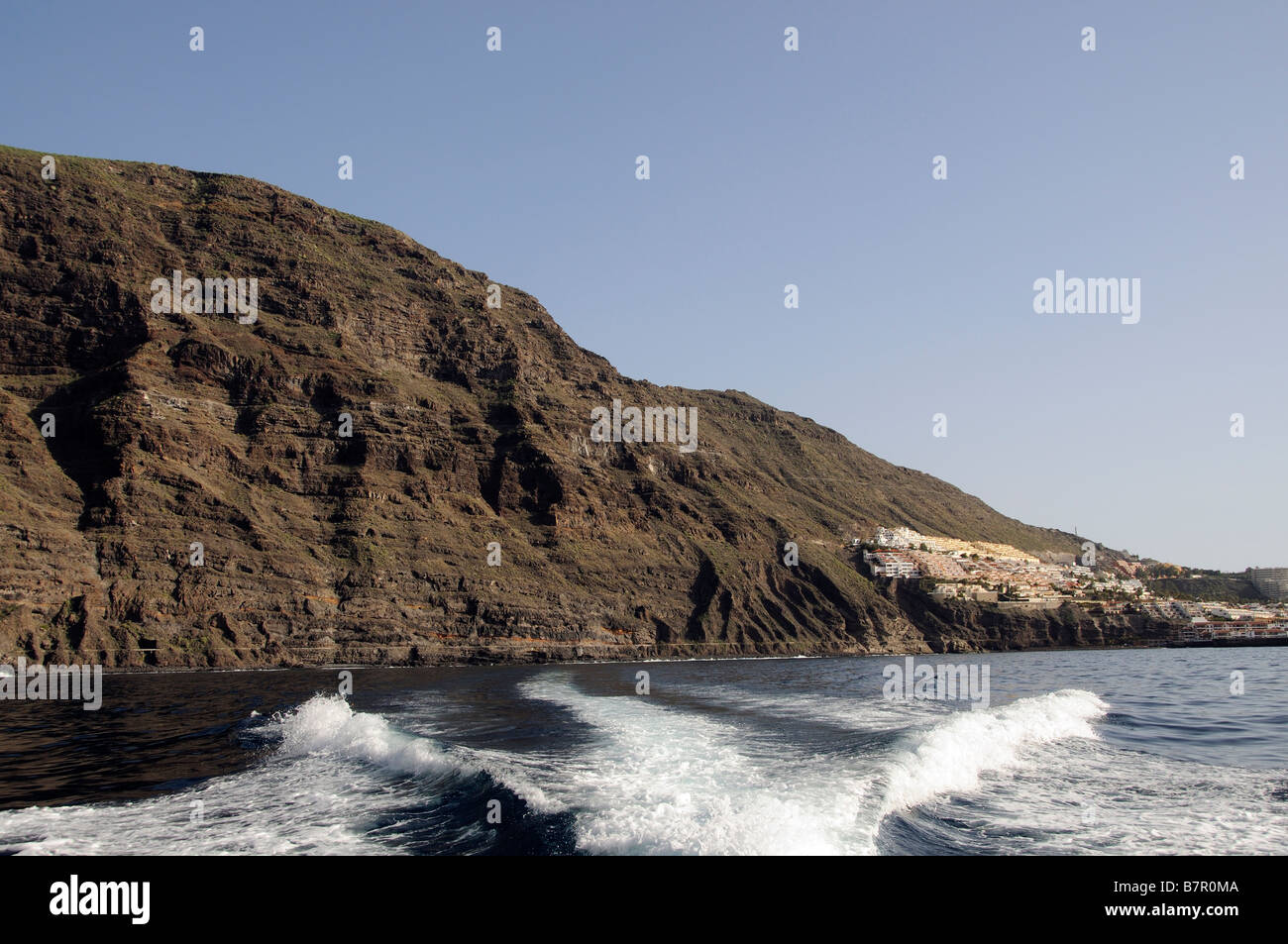 Los Gigantes Cliffs and in the distance the harbour and town a popular Tenerife holiday resort. Canary Islands Stock Photo