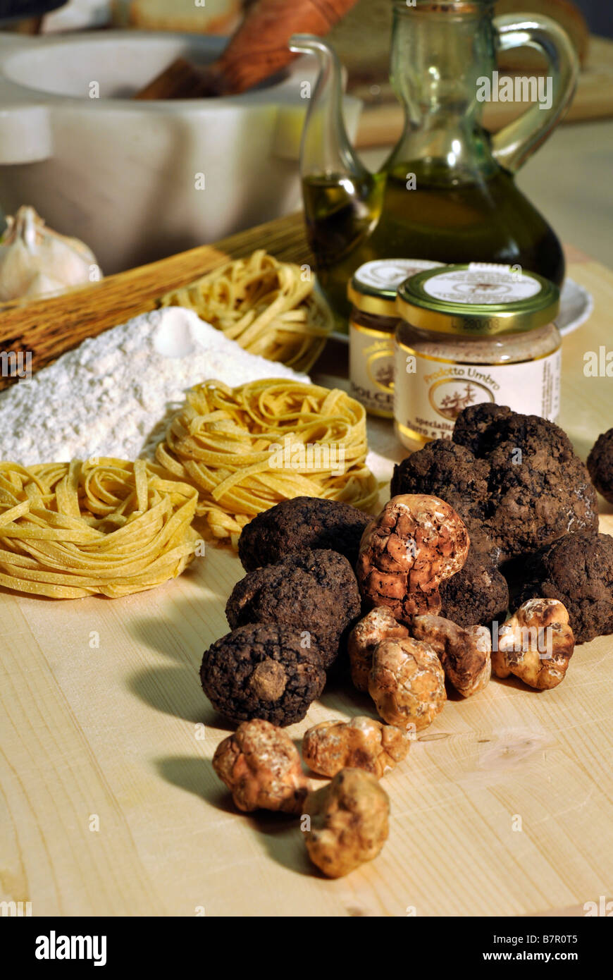Fresh black and white truffles with jars of truffle butter and ...