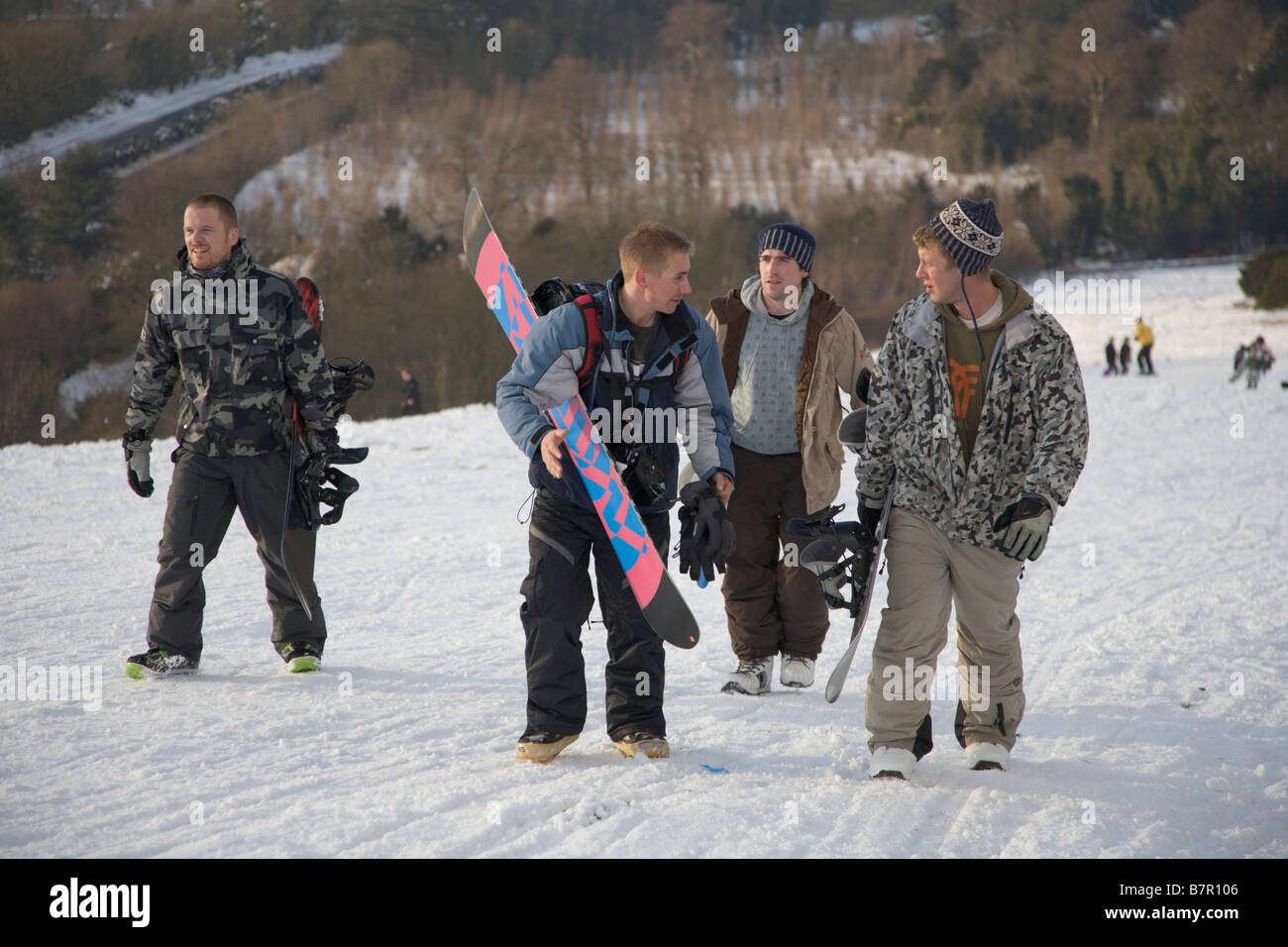 Snowboarders climb up Box Hill Near Dorking Surrey during severe winter weather 2009 Stock Photo