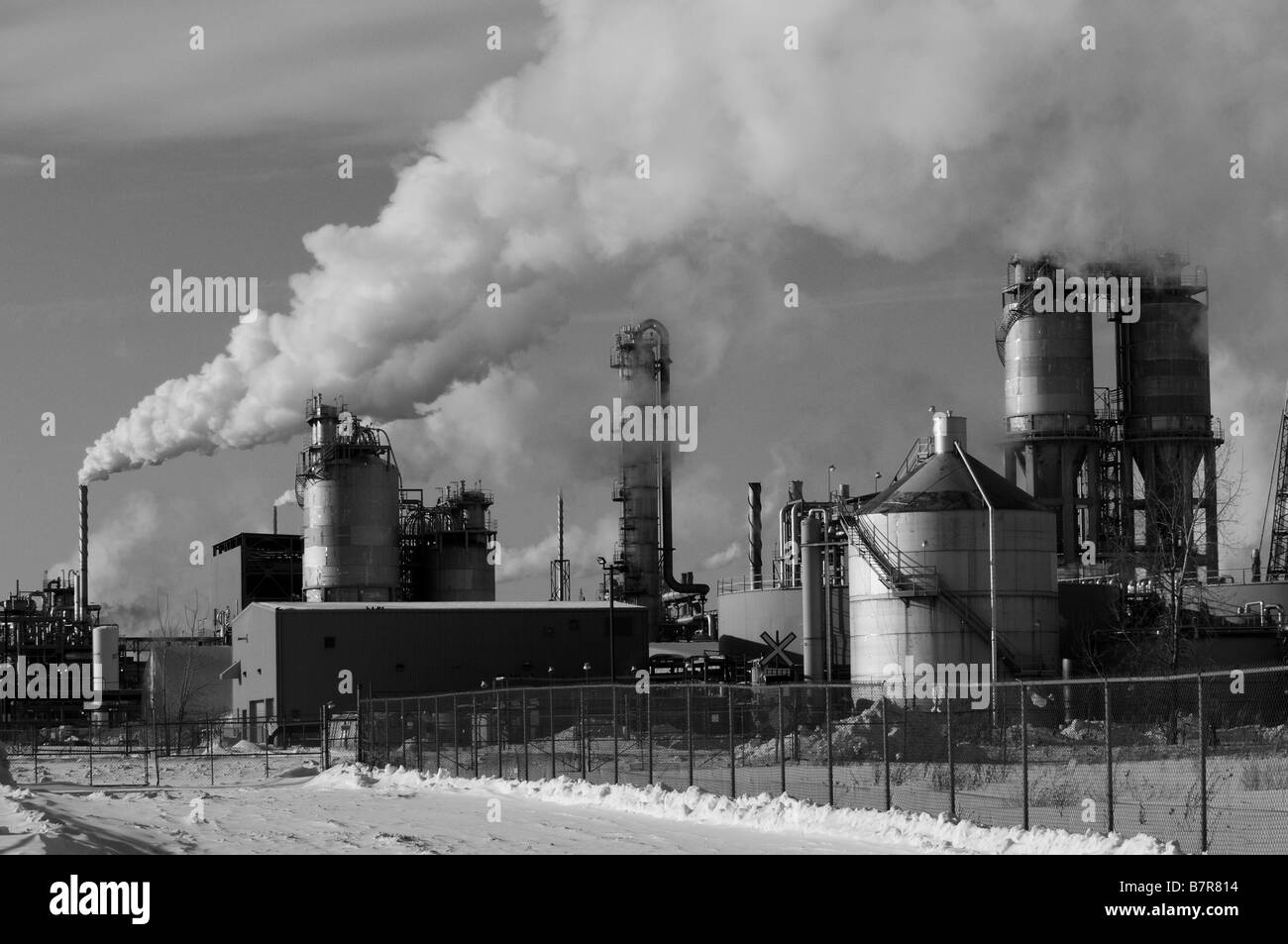 Smoke billowing from the smoke stacks of an oil refinery, pollution and global warming. Save the environment, economic disaster. Stock Photo