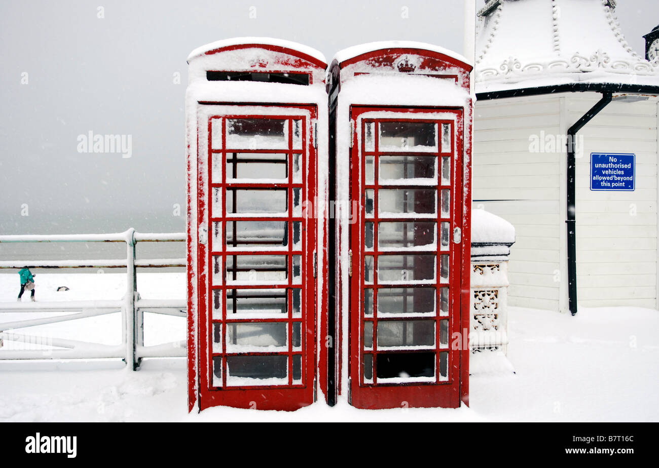 Red telephone boxes in the snow at Brighton UK Stock Photo