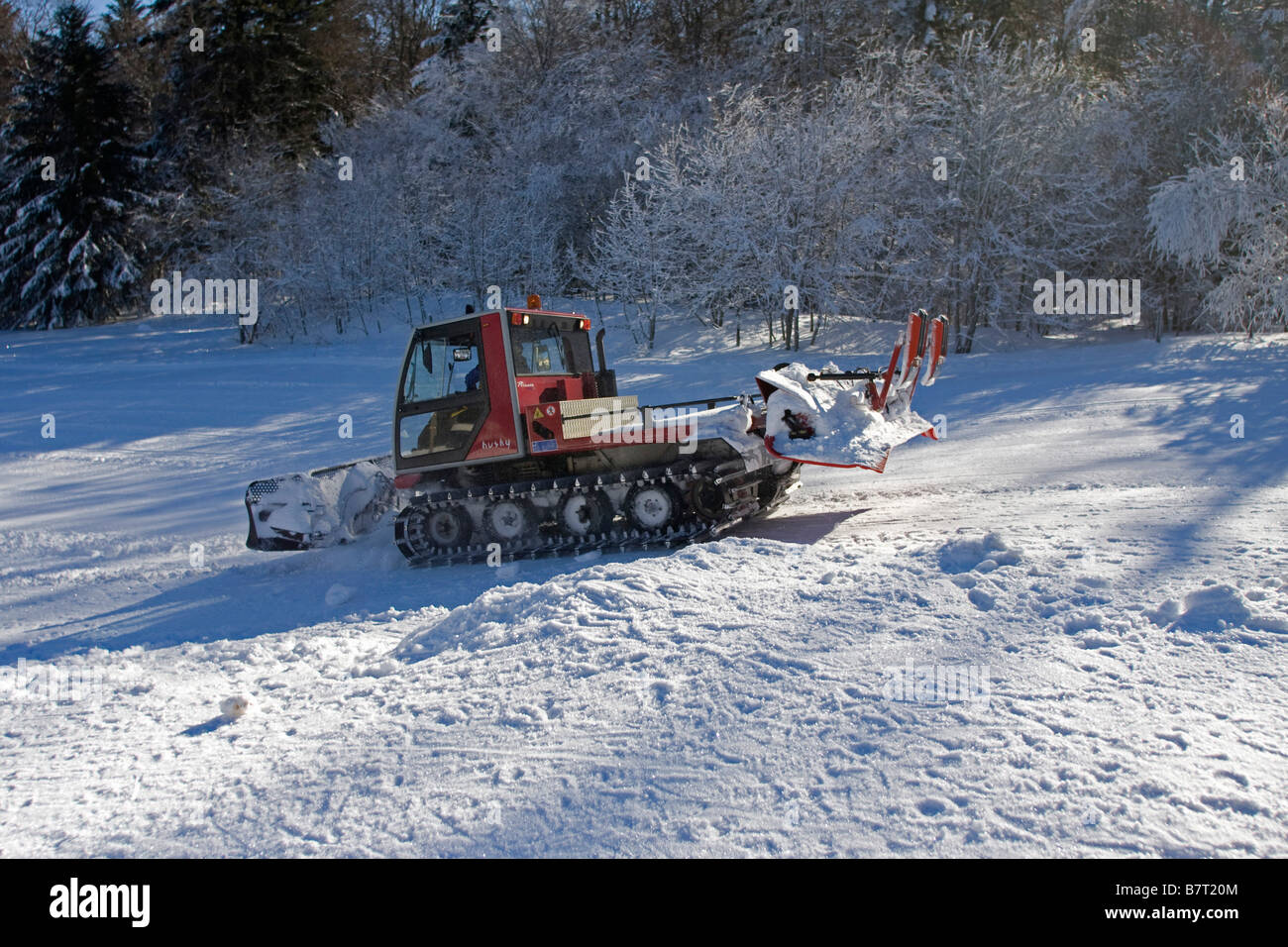 Snow plough caterpillar working on ski slope hires stock photography