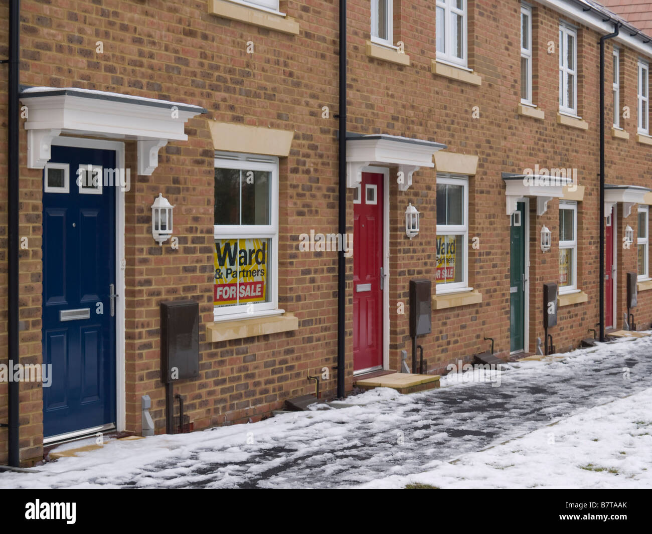 Terrace of new build houses for sale in the snow Britain UK Stock Photo