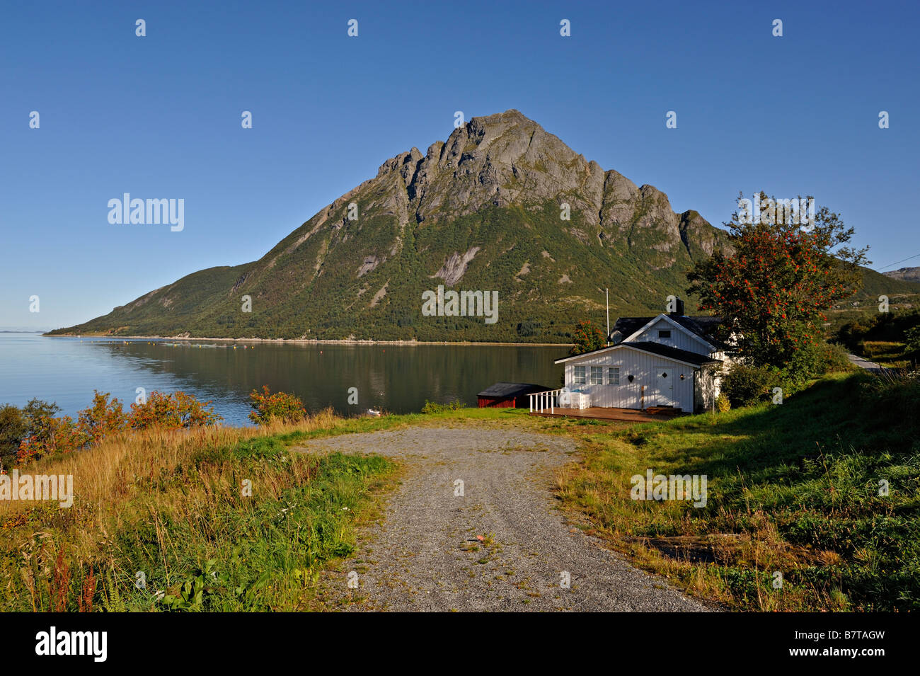 House at Lia on the Aldra Sound with the peak of Okstind behind north west Norway Stock Photo