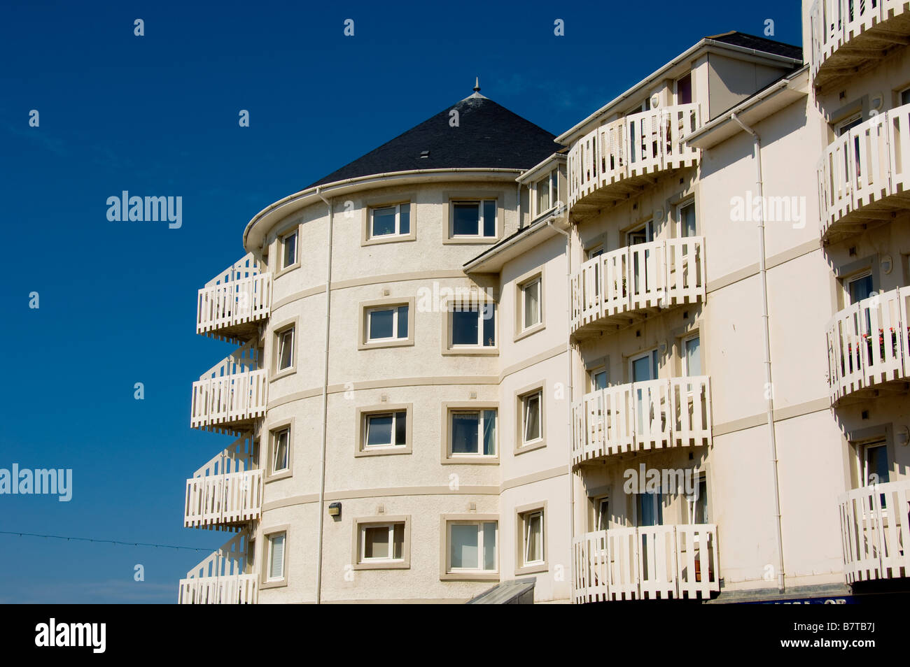 Modern creamy white rendered seafront apartments with curving walls and