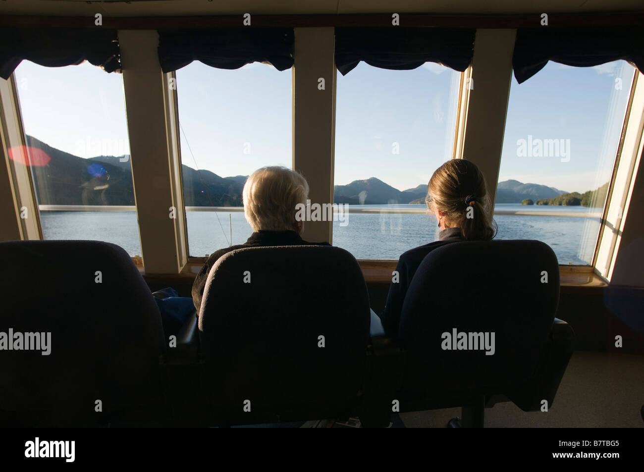 Tourists looking out the window of the observation deck of the Alaska Marine Highway along the Inside Passage Southeast Alaska Stock Photo