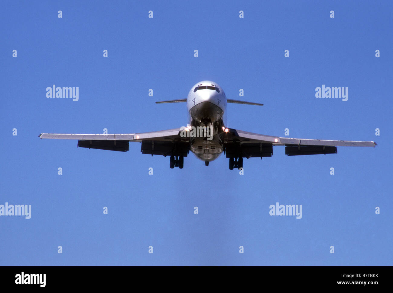 Jet approaches airport with gear and flaps down just before landing Stock Photo