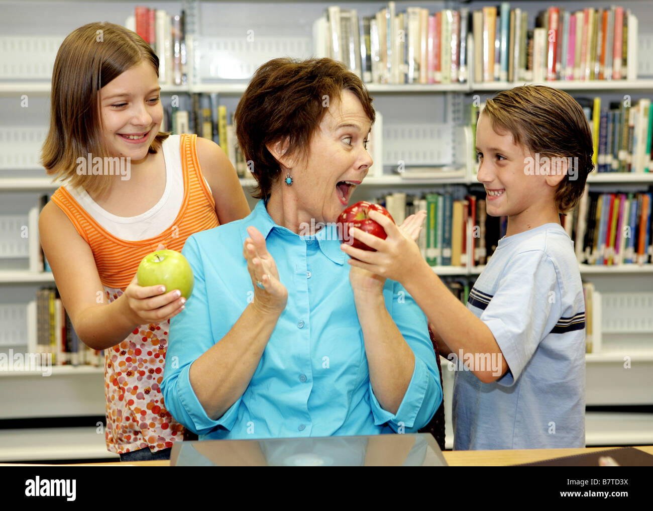 Two students giving apples to their favorite teacher She is very