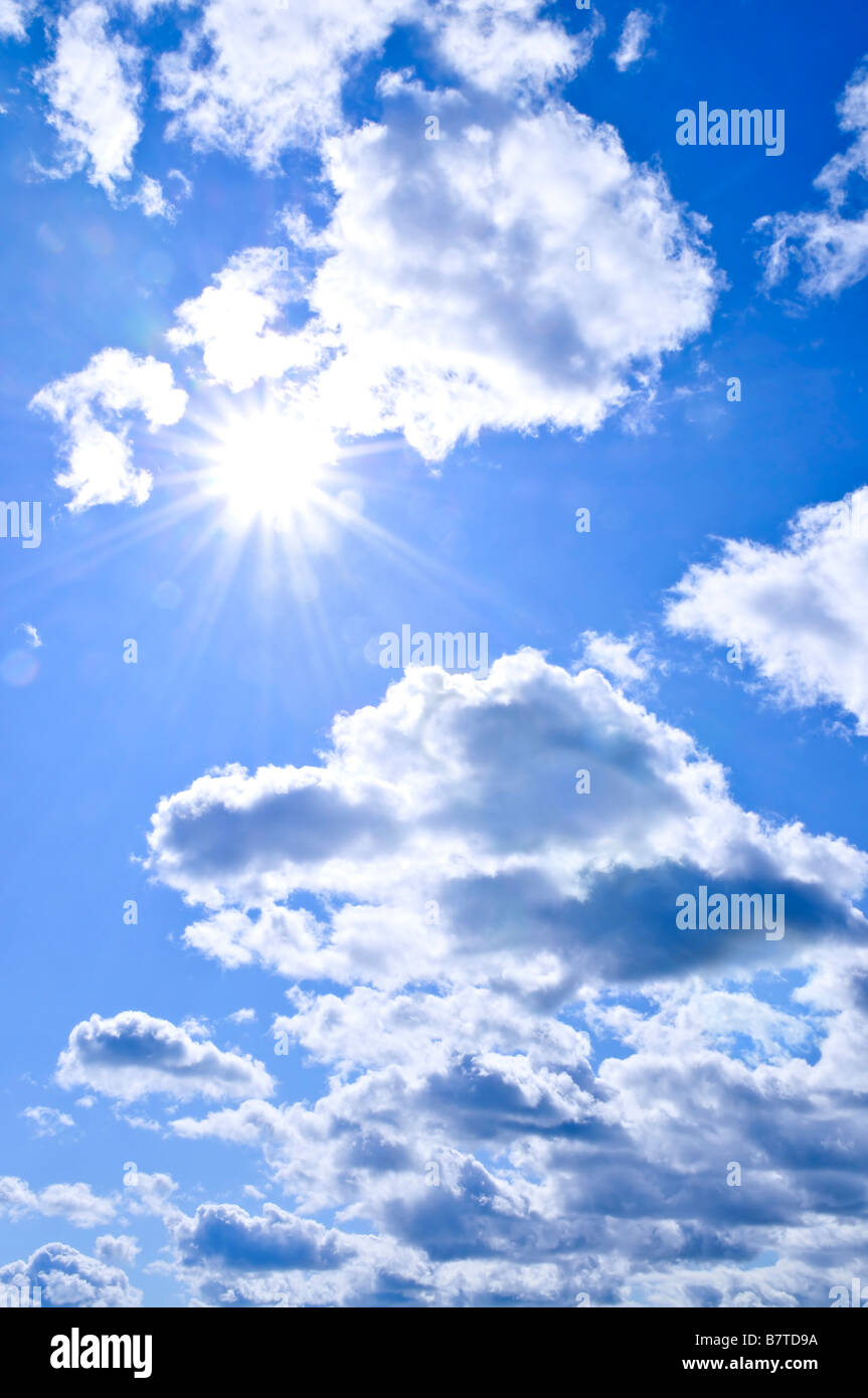 Background of blue sky with shining sun and clouds Stock Photo