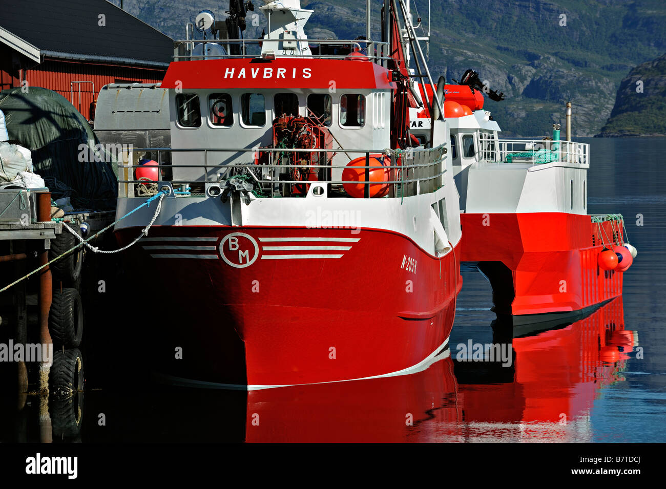 Red boats tied up in harbour at Kilboghamn on Sorfjord north west Norway Stock Photo
