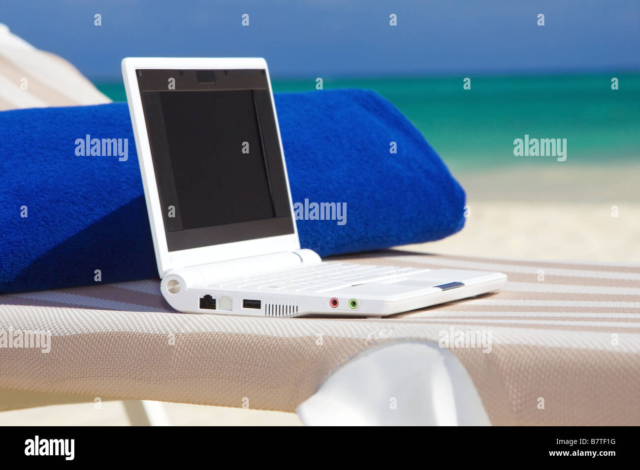 laptop computer and towel on the beach chaise longue Stock Photo - Alamy