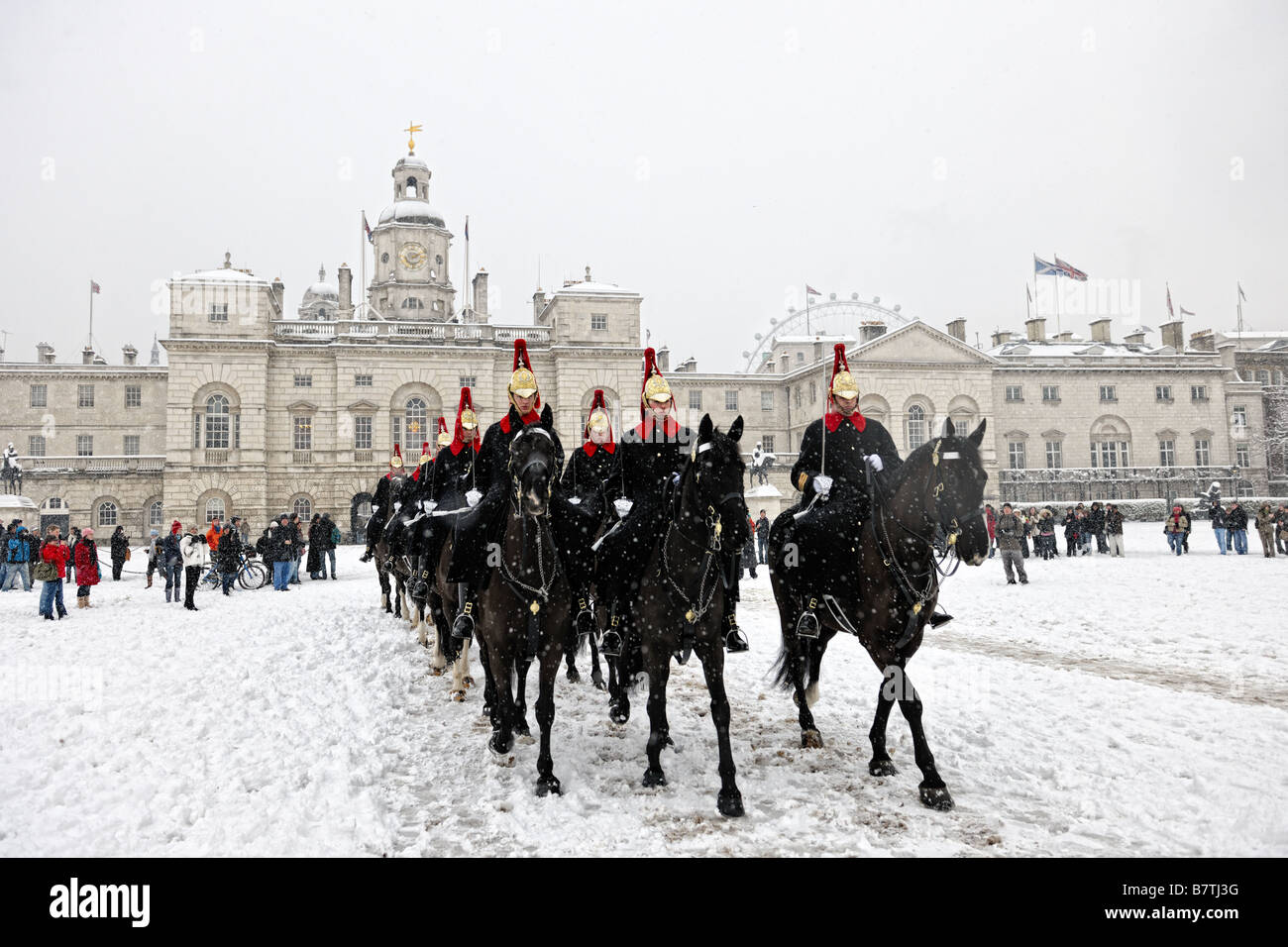 The Household Cavalry riding throug the snow across Horseguards Parade for duties at Buckingham Palace after a change of guard Stock Photo
