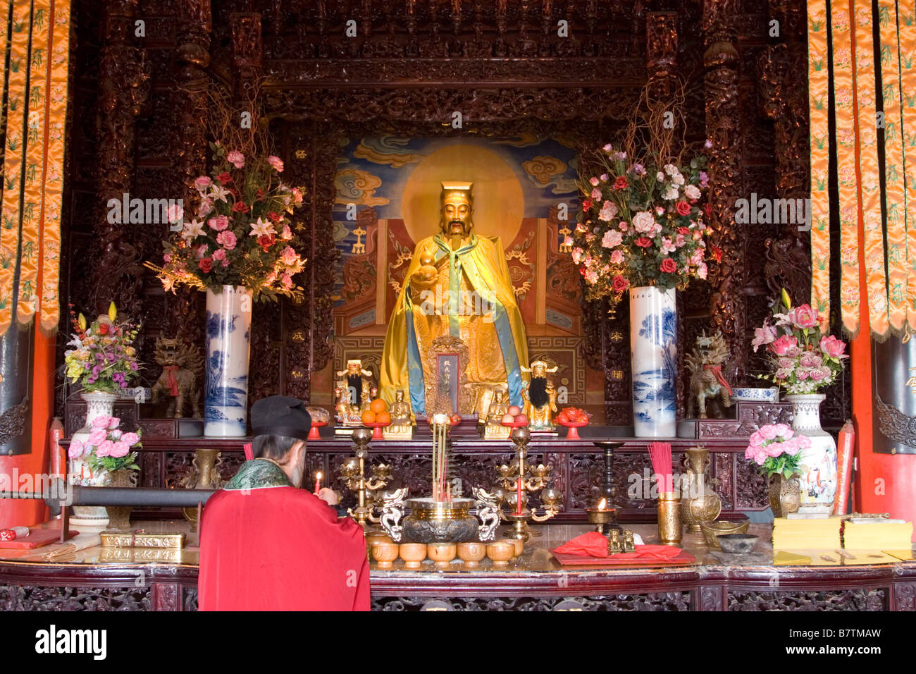 Tao monk lights candles at the shrine of the god called Xian Zu Dian at Ming Sheng Gung Tao temple in Xian in China. Stock Photo
