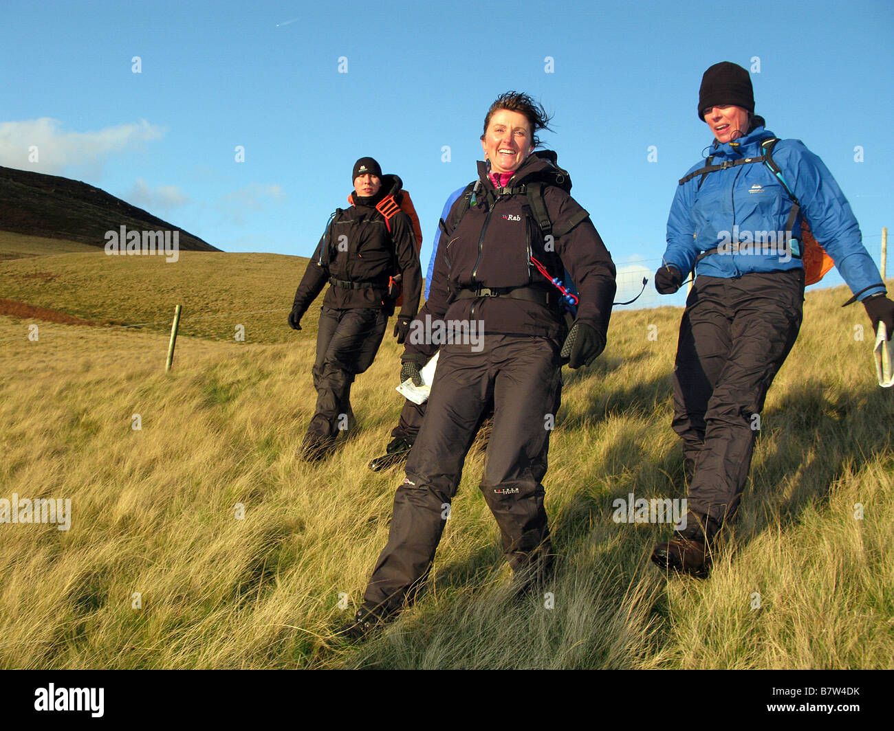 Three hillwalkers happy on a moor in the Peak District National Park Stock Photo