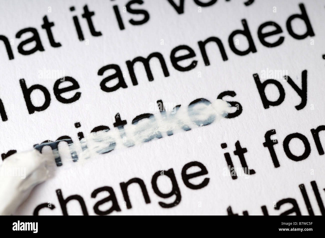 Stock photo of the word mistakes on a piece of paper being erased with white correction fluid Stock Photo