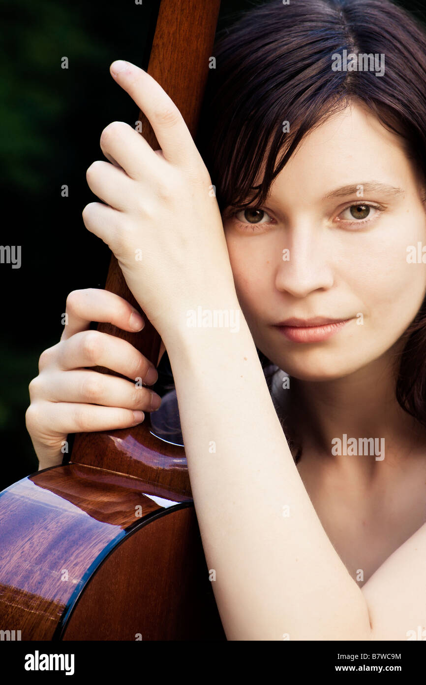 Young pretty woman holding her classic guitar Stock Photo - Alamy
