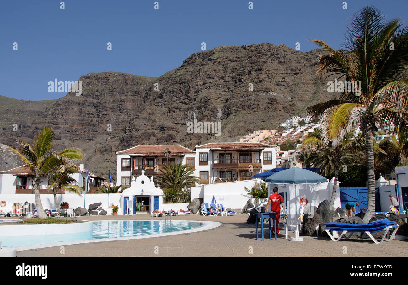 Tenerife holiday resort swimming pool and mountains located at Los Gigantes Stock Photo