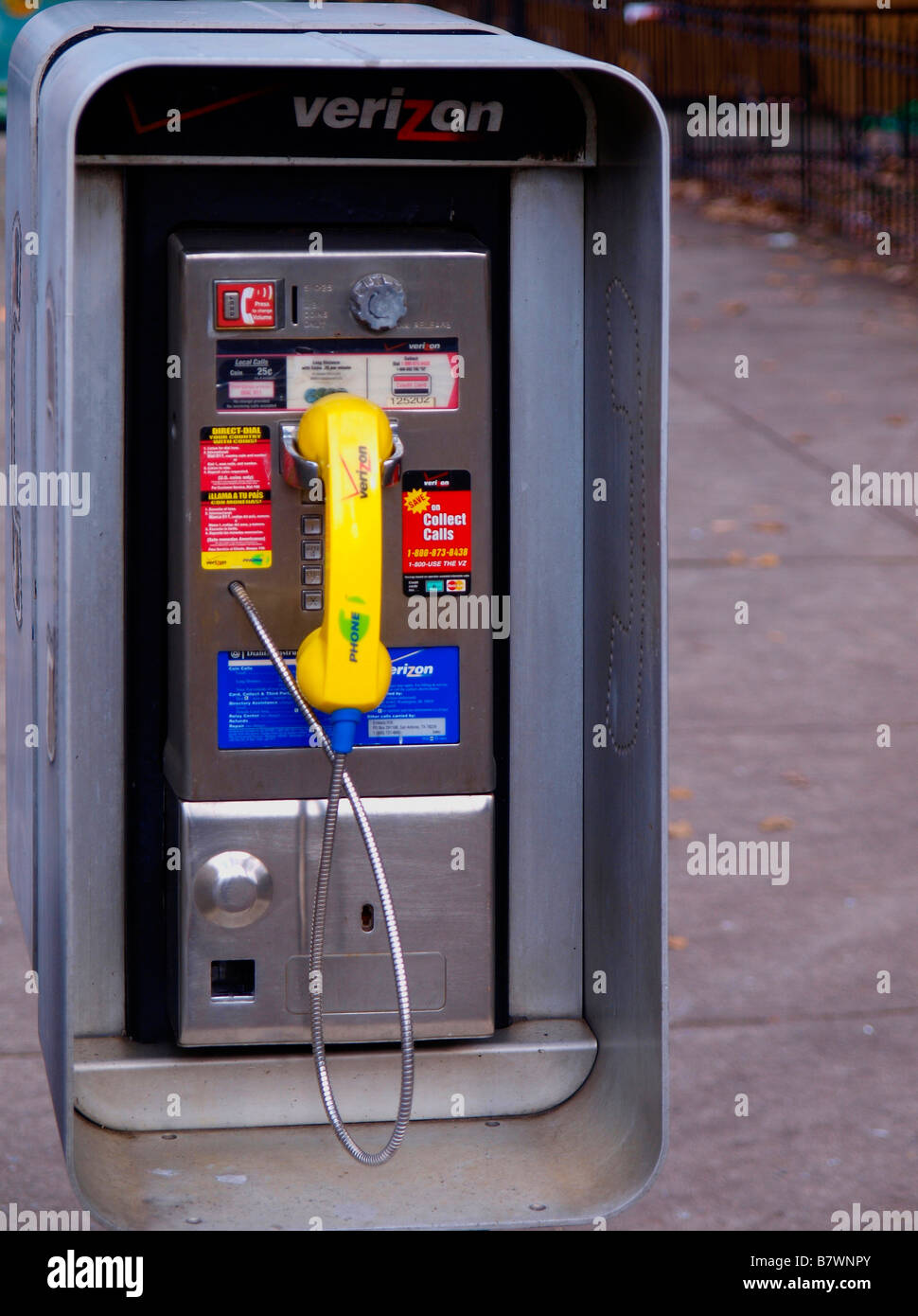 Dirty, colorful pay telephone looking old-fashioned in a modern urban setting. Stock Photo
