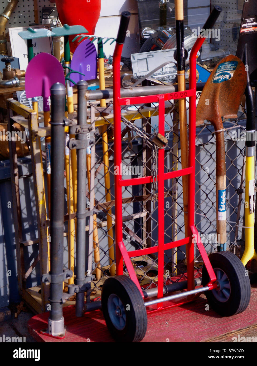 Colorful home and garden tools including a hand truck, shovels, spades