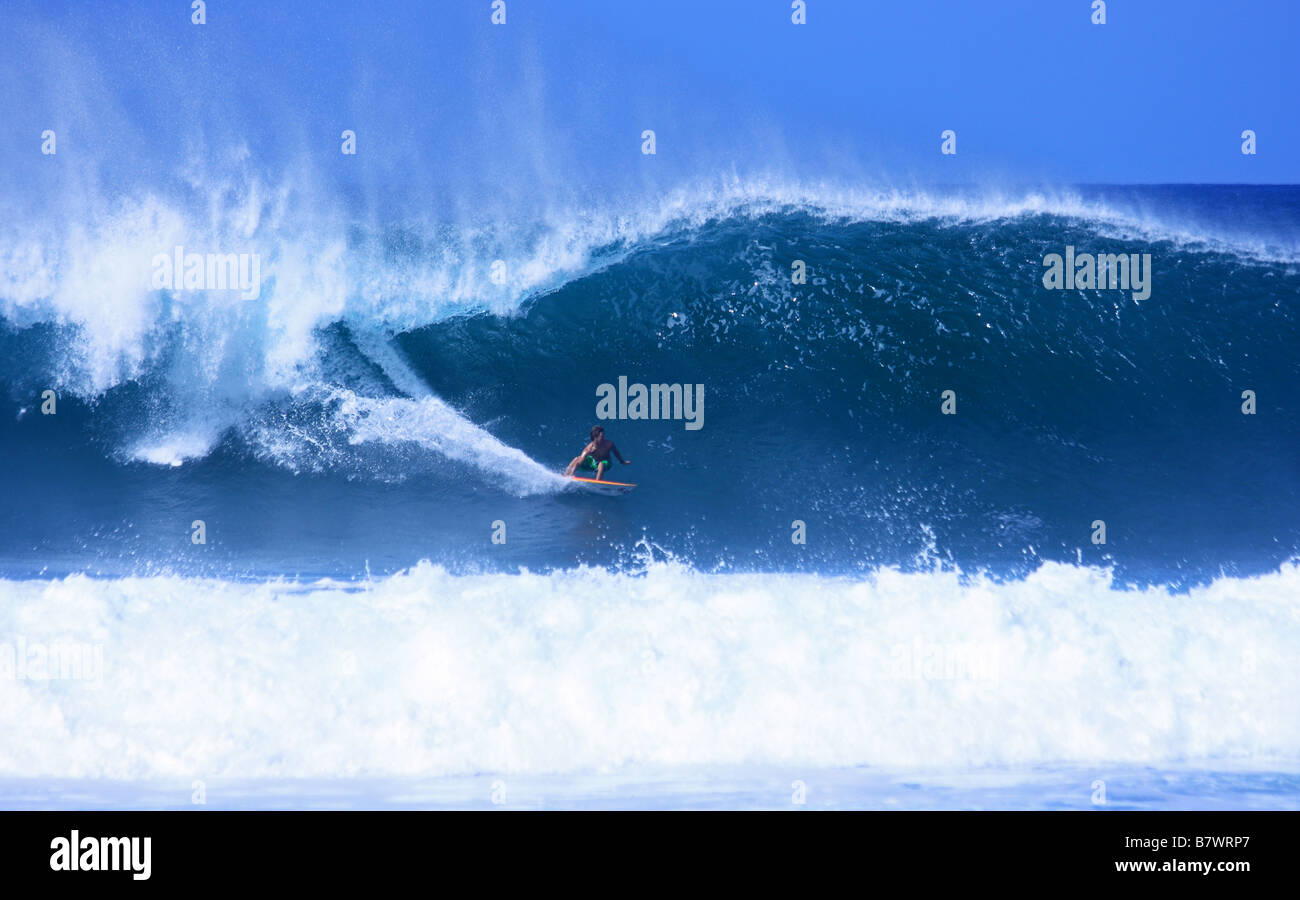 Surfer taking off at Rocky Point on Oahu North Shore, Hawaii USA Stock Photo