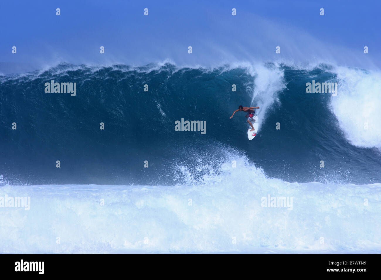 Surfer taking off at Backdoor on Oahu North Shore, Hawaii USA Stock Photo