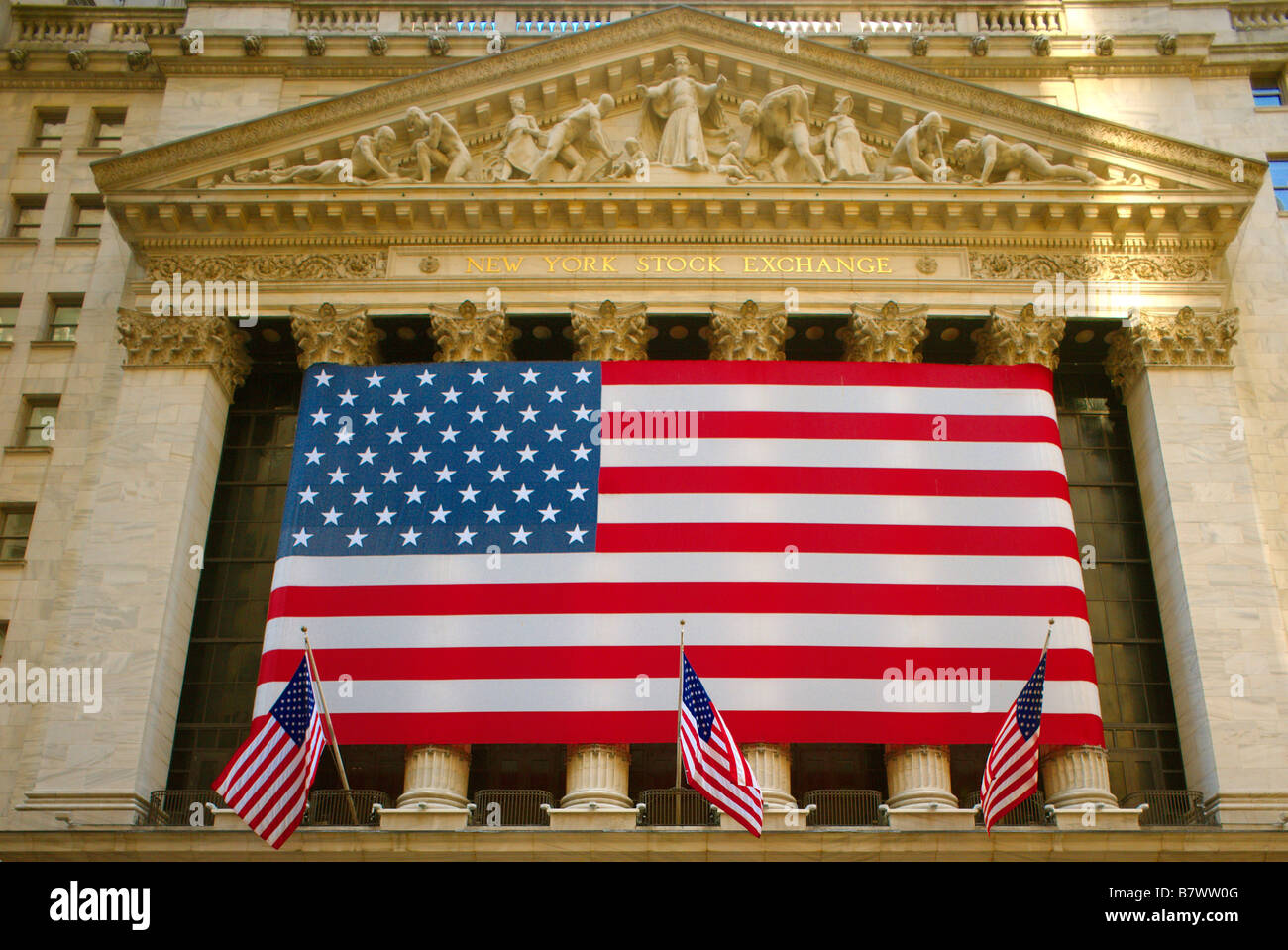 Stars & Stripes USA flag banner across frontage of New York Stock Exchange Stock Photo