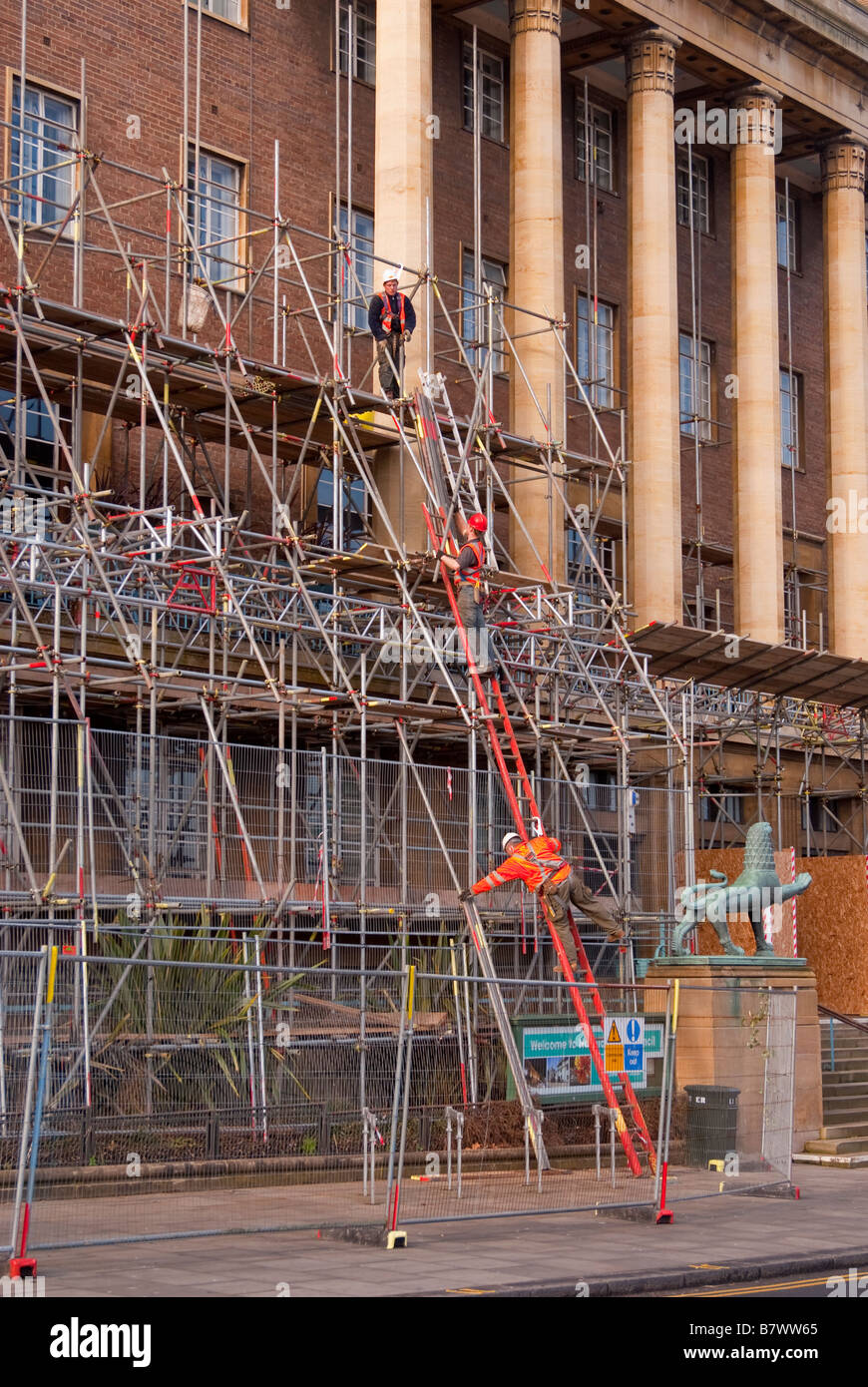 Building work and scaffolding being erected by scaffolders around large