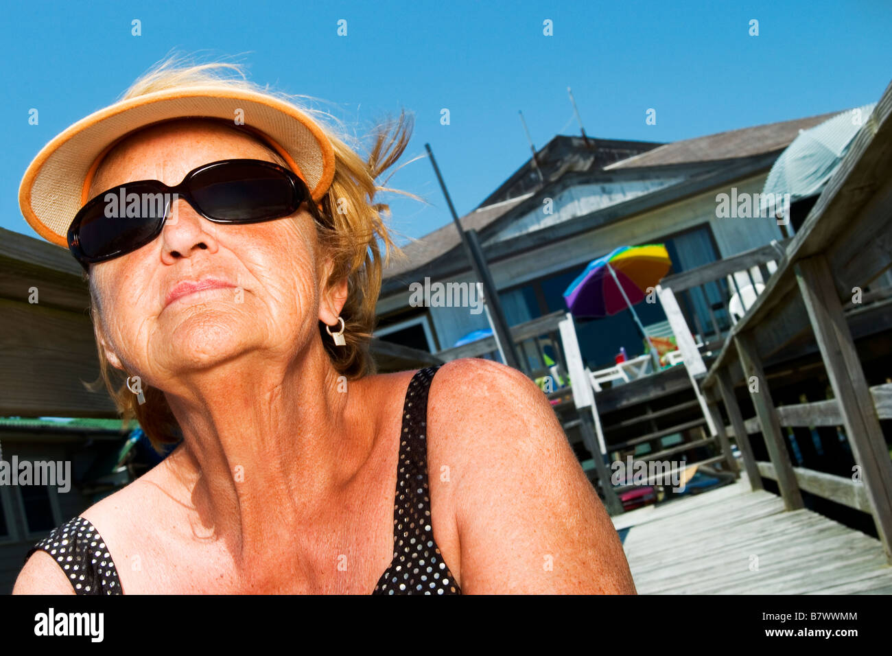 woman sitting on stairs at beach house getting a tan Stock Photo