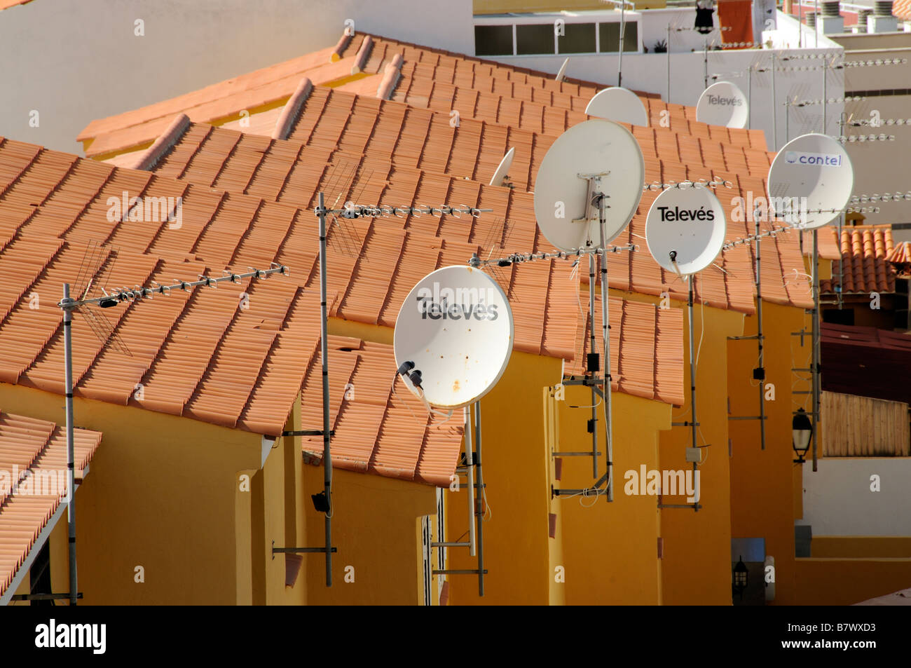 Television aerials and signal reception satellite dishes situated on rooftop of spanish properties Stock Photo